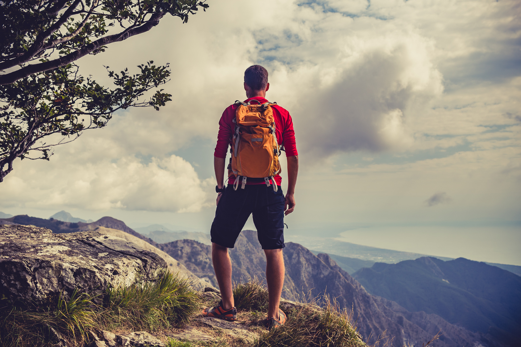 Wanderer steht auf Bergspitze