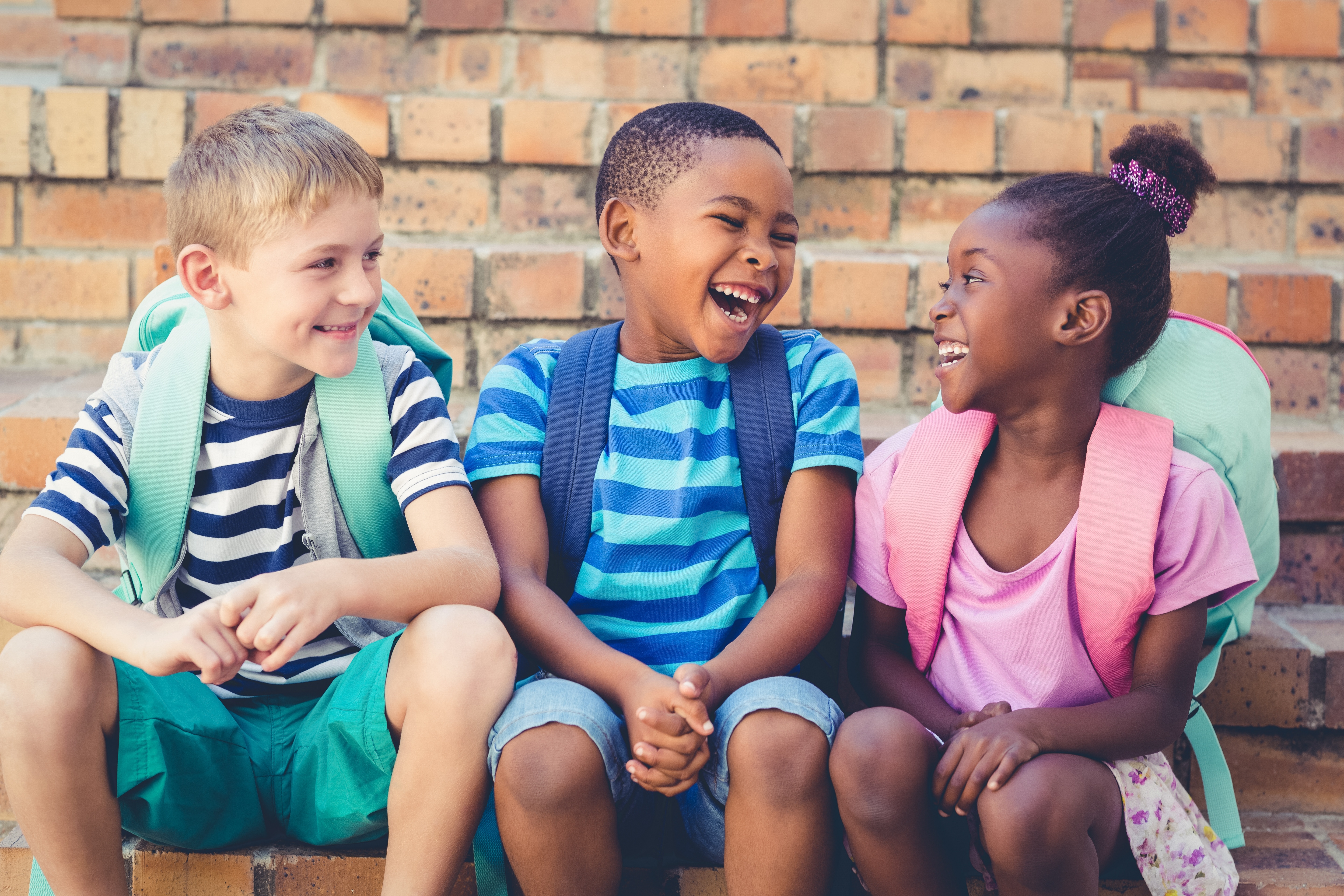 Drei Kinder lachen gemeinsam