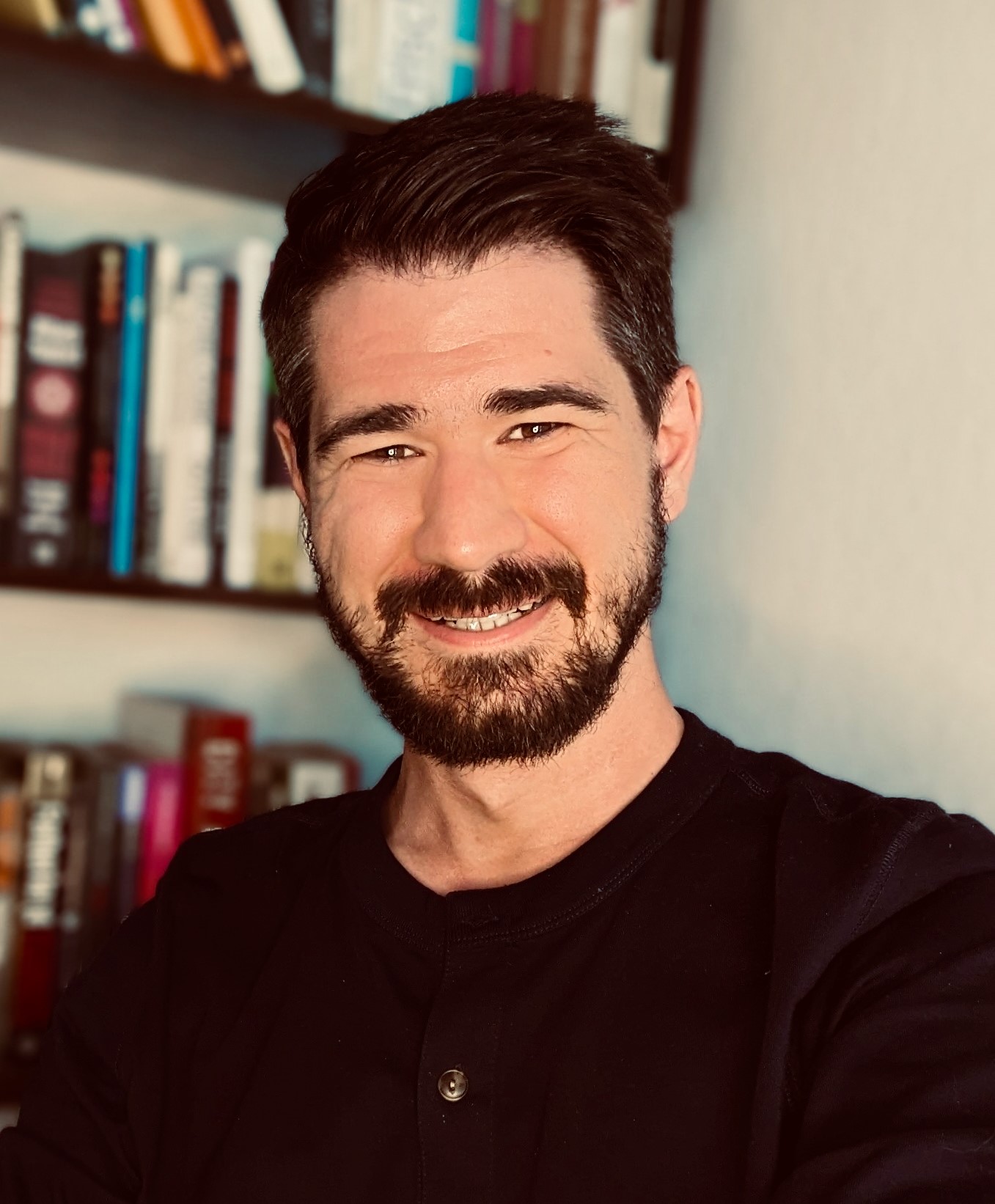 Foto von einem Mann vor einem Bücherregal