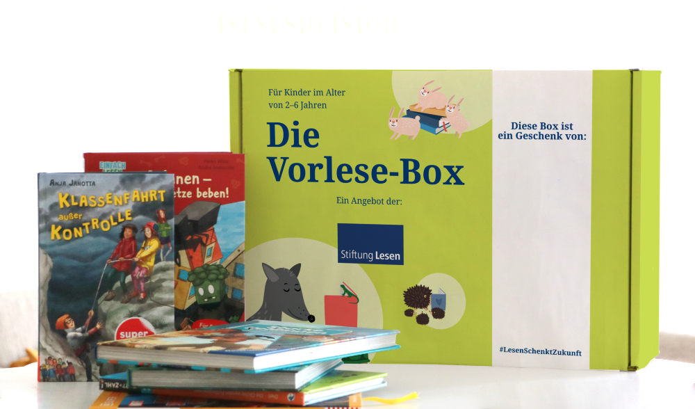 Die grüne Vorlese-Box steht neben einem Bücherstapel