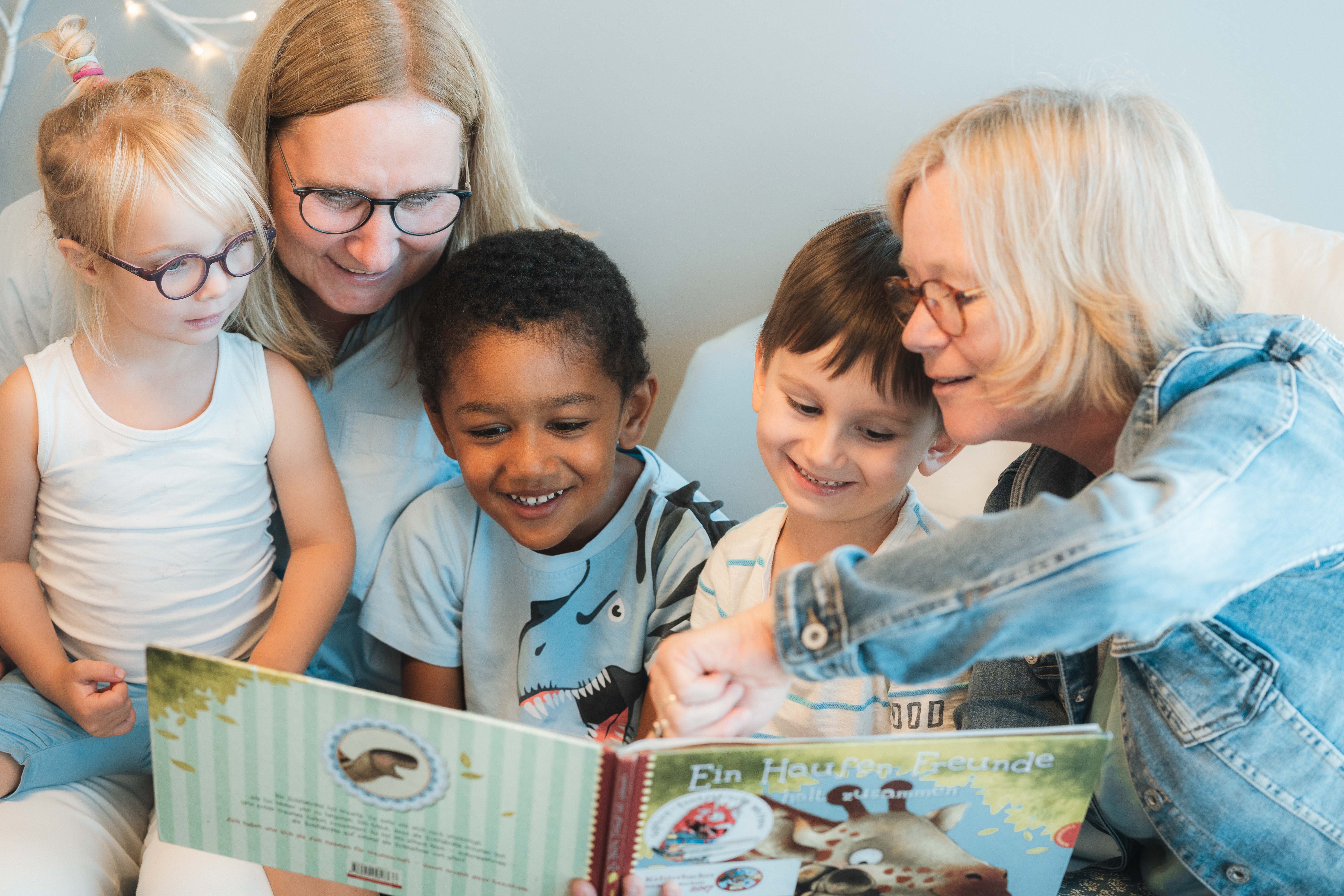 Drei Kindern wird vorgelesen