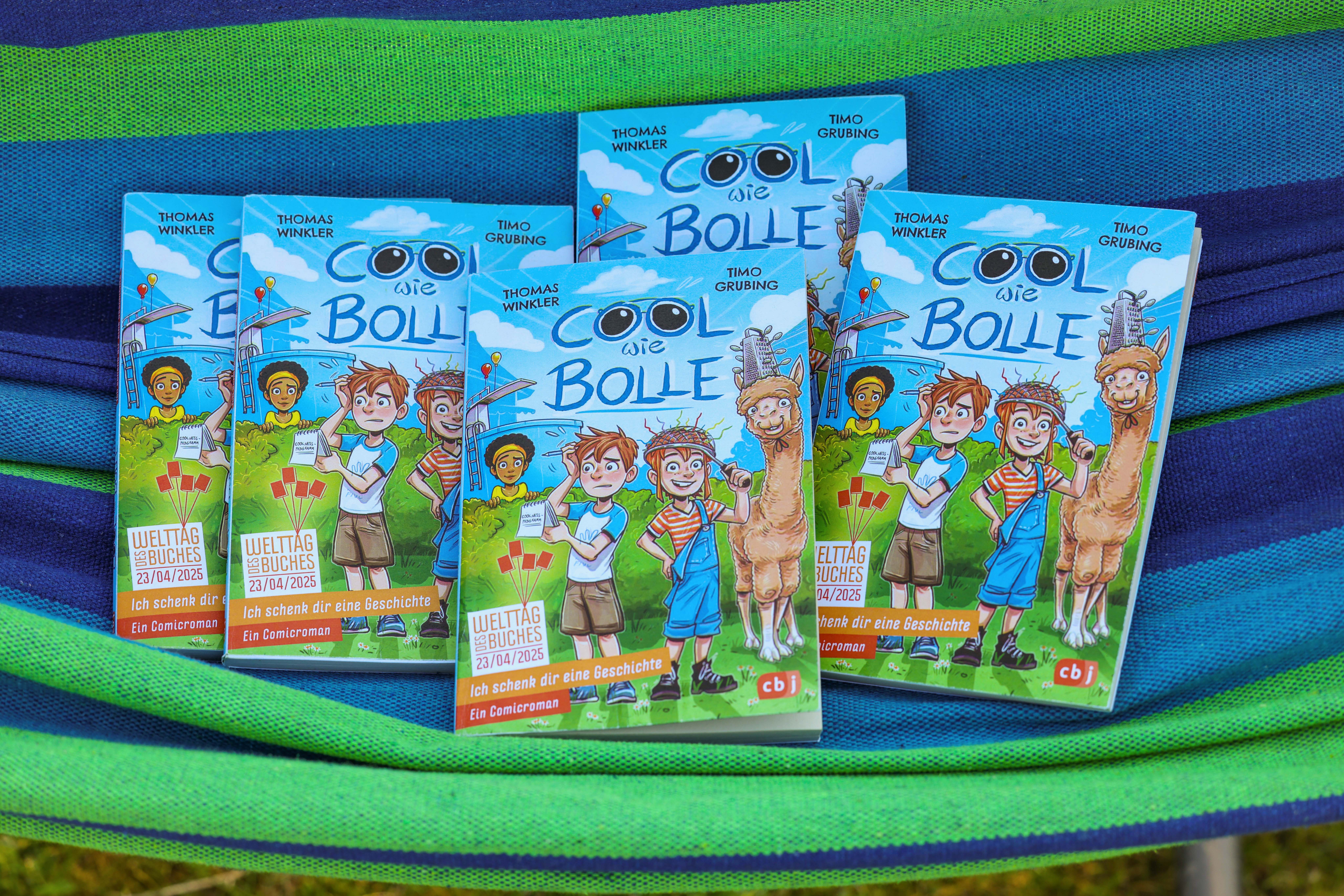 In einer Hängematte liegen mehrere Exemplare des Welttagsbuches 2025 "Cool wie Bolle" von Autor Thomas Winkler und Illustrator Timo Grubing.