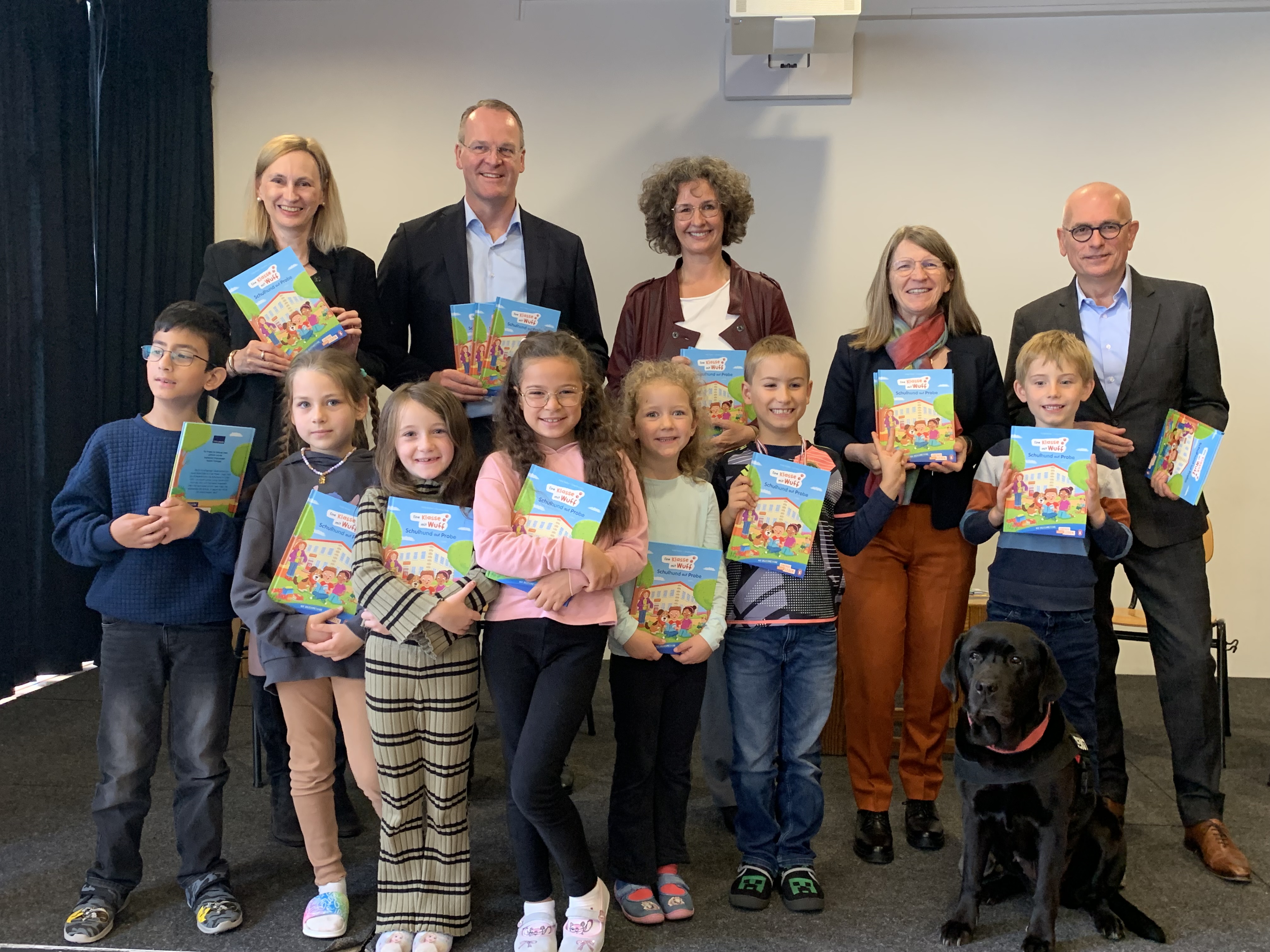 Von links: Antje Schwarz (Pressereferentin Sparkassen- und Giroverband Hessen-Thüringen), Stefan G. Reuß (Geschäftsführender Präsident des SGVHT), Sabine Uehlein (Geschäftsführerin Programme Stiftung Lesen), Brigitte Hirschler (Referatsleiterin Stiftungen und Wettbewerbe im Kultusministerium Hessen), Oliver Klink (Vorstandsvorsitzender der Taunus Sparkasse) mit Kindern der Regenbogen Grundschule in Hattersheim und Schulhund Haley.
