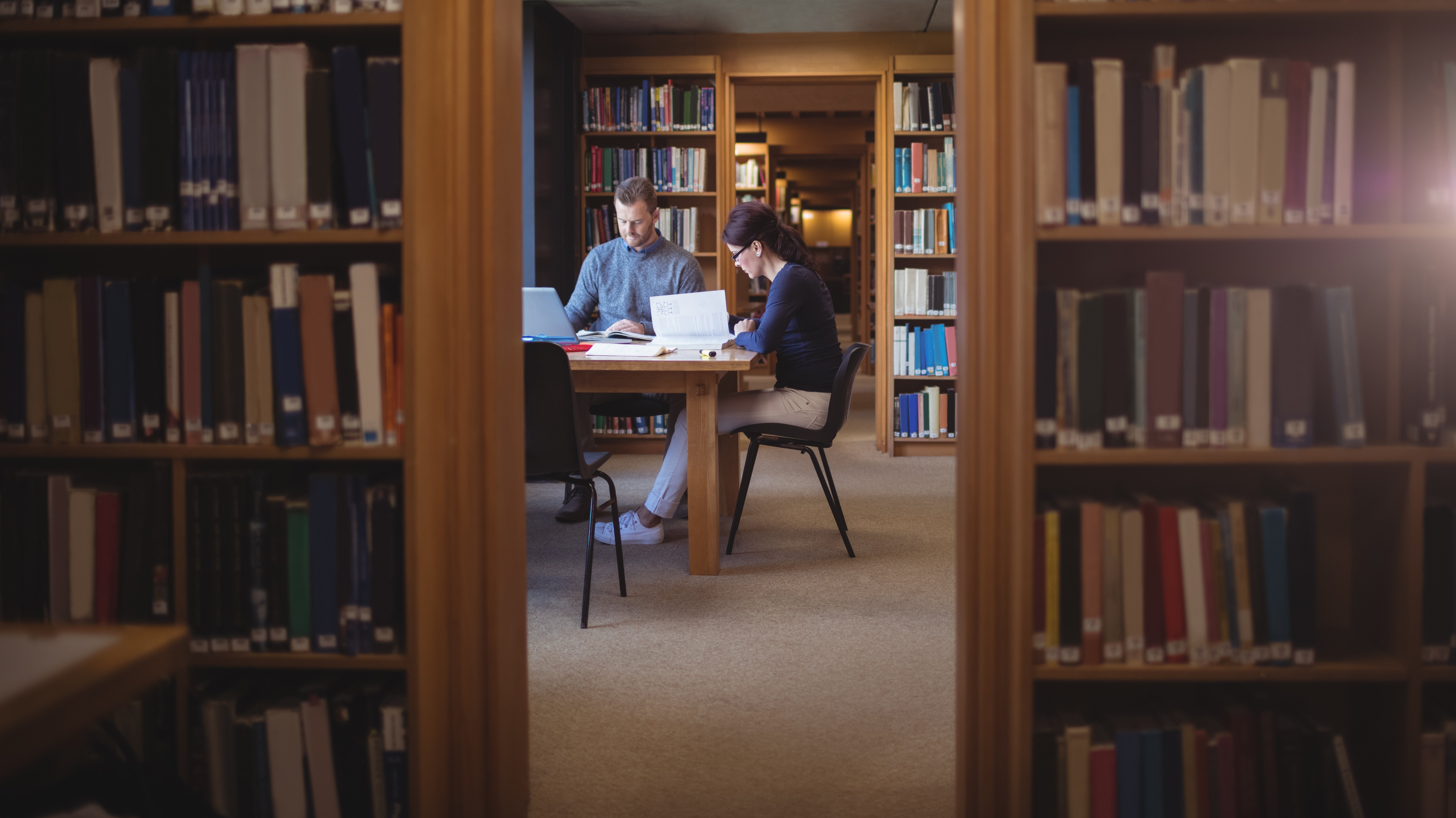 Mann und Frau lesen in Bibliothek