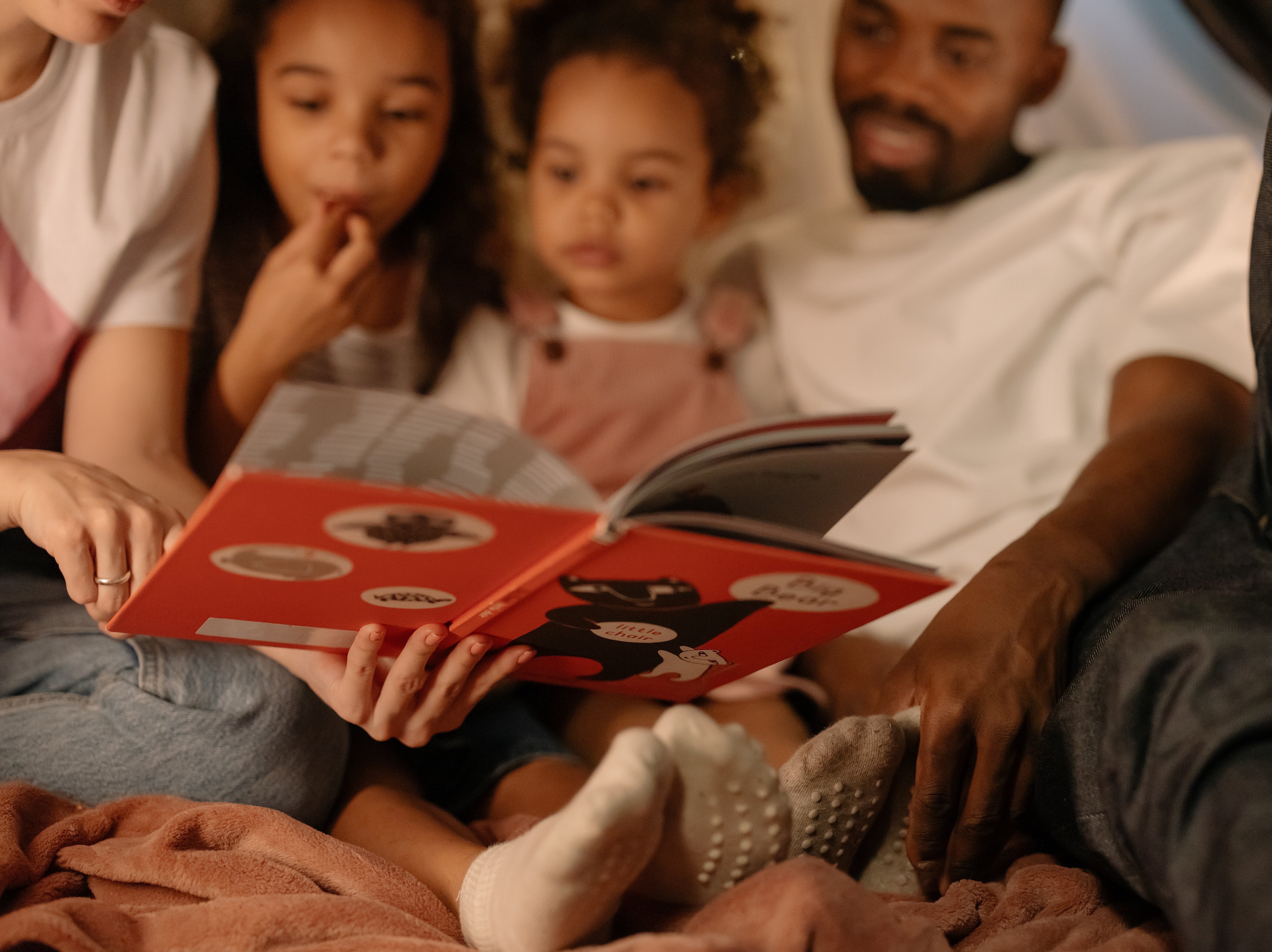 Vater und Mutter lesen ihren beiden Kindern vor