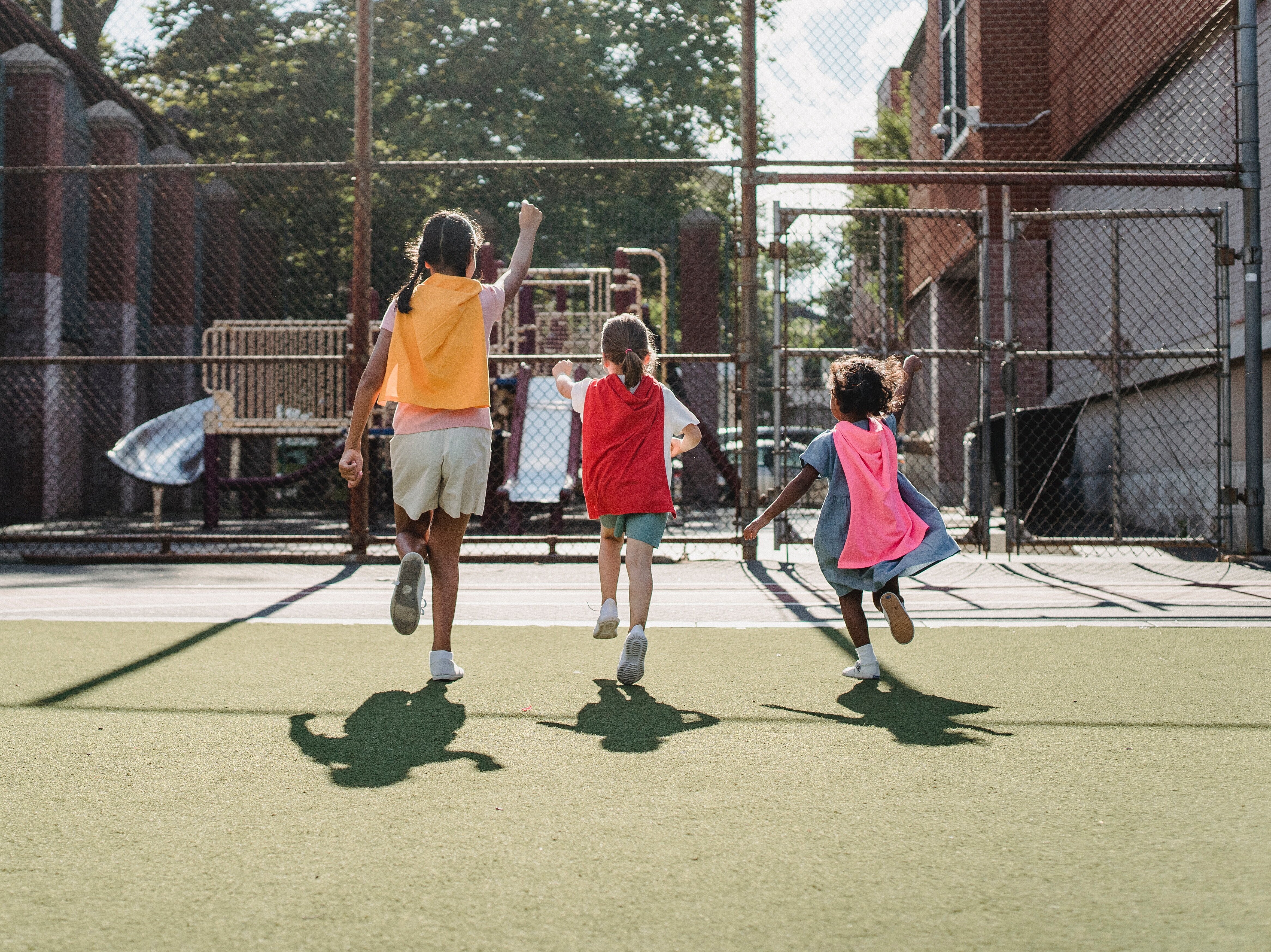 Kinder spielen mit Superhelden-Umhang
