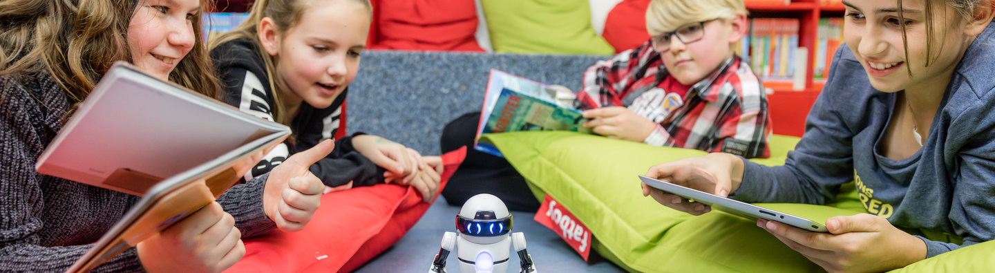 Kinder lesen und beobachten Roboter