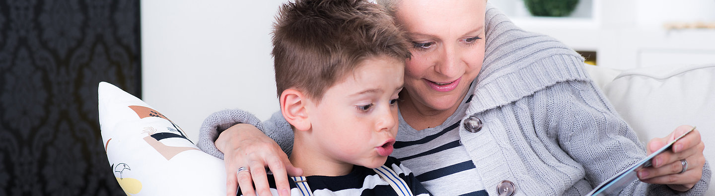 Mutter und Sohn lesen auf der Couch